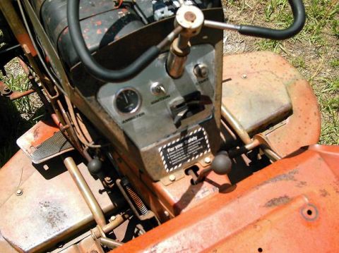 1986 Ford Bronco - The dashboard of a tractor shows an ammeter, ignition, and start switches, along with a safety warning label.