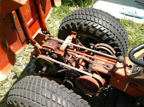 1986 Ford Bronco - Close-up of an orange lawn tractor's engine and tires, showing mechanical components.