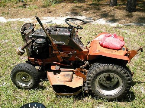 1986 Ford Bronco - A Simplicity riding mower sits outdoors on a grassy area with trees in the background.