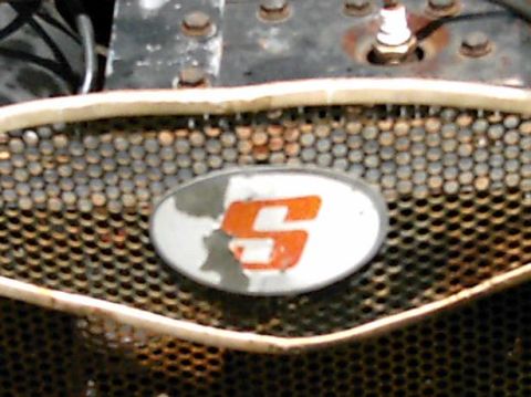 1986 Ford Bronco - Grille detail with an oval emblem an orange 'S' symbol.
