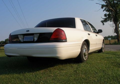 2001 Ford Crown Victoria - White 2001 Ford Crown Victoria seen from the rear on a sunny day.