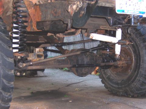 1978 Ford Bronco - The vehicle's undercarriage shows significant rust and modifications to the suspension system.