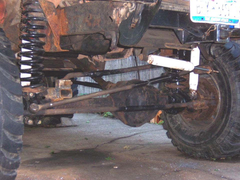 Vehicle undercarriage with heavy rust, large tires, and aftermarket suspension components