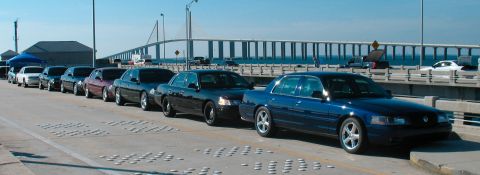 1997 Ford Crown Victoria - Several Ford Crown Victoria sedans are lined up on a bridge under a clear sky.