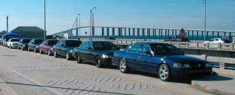 1997 Ford Crown Victoria - A line of Ford Crown Victoria sedans, including a blue model in the foreground, are parked on a bridge.