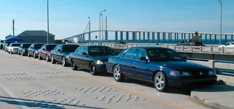 1997 Ford Crown Victoria - A line of Ford Crown Victoria police interceptors are parked on a bridge under a clear blue sky.