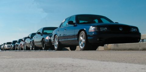 1997 Ford Crown Victoria - Several Ford Crown Victorias are lined up on a sunny day, with one car prominently featured in the foreground.