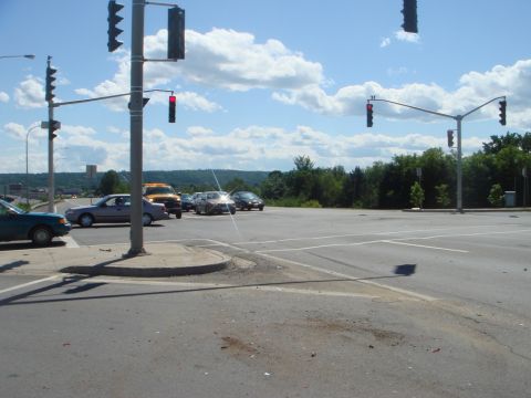 1996 Ford Bronco - Multiple vehicles are visible at a traffic intersection on a sunny day.