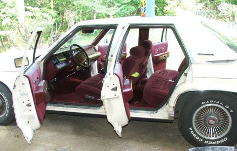 1991 Ford LTD Crown Victoria - Interior view of a 1991 Ford Crown Victoria LTD, showing maroon upholstery and open doors.