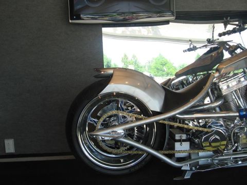 1988 Ford Bronco - Close-up view of a custom motorcycle's rear wheel, chain drive, and engine components, extensive chrome detailing.