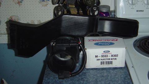1986 Ford Bronco - A Ford Racing injector kit box sits beside a black air intake component on a countertop.