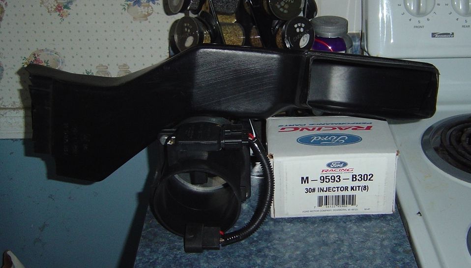 Ford Racing 30 lb injector kit box with mass air flow sensor and black intake duct on a kitchen counter