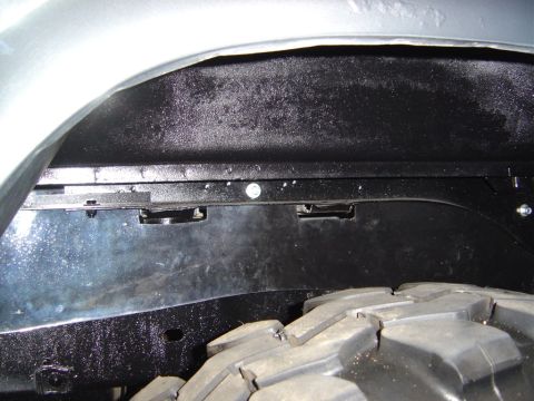 1986 Ford Bronco - The interior of a vehicle's wheel well is shown, with a tire visible at the bottom right.