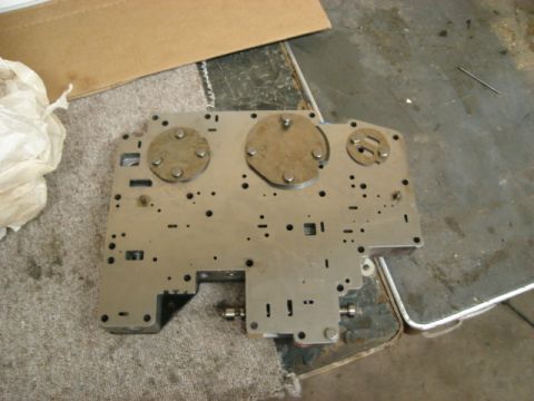 1992 Ford Crown Victoria - This is a close-up view of a metal component with multiple circular covers and various holes.