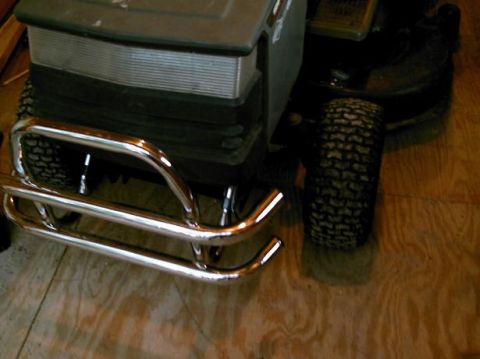 1986 Ford Bronco - A close-up view of a chrome bumper attached to the front of a lawn mower.