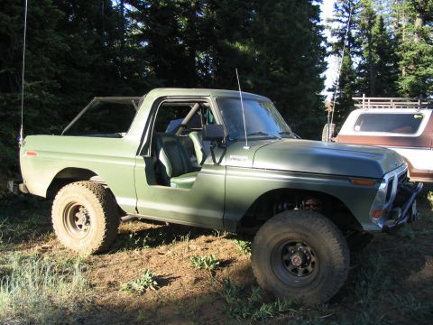 1979 Ford Bronco - This 1979 Ford Bronco, with its doors off, is seen parked in a wooded area next to another vehicle.