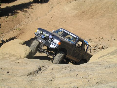1979 Ford Bronco - This modified truck is navigating a challenging off-road course, with a second vehicle in the distance.