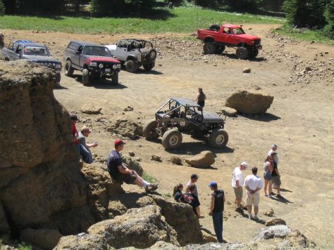 1979 Ford Bronco - Off-road vehicles and spectators gather on a rocky, dirt terrain during an event.