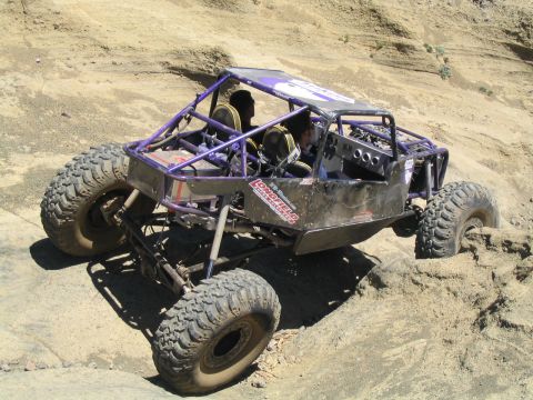 1979 Ford Bronco - Custom rock crawler buggy with two occupants navigating challenging sandy terrain.
