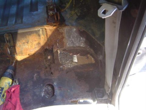 1979 Ford Bronco - The interior floor pan shows significant rust damage and holes.