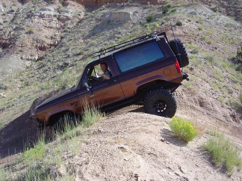 1986 Ford Bronco II - 1986 Ford Bronco II navigating a challenging off-road trail.