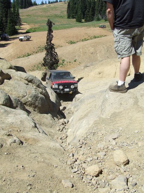 1979 Ford Bronco - An off-road SUV navigates a challenging rocky terrain, with another vehicle visible in the distance.