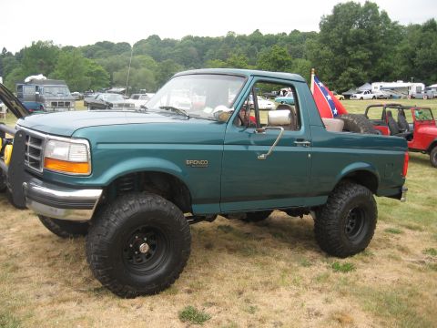 1996 Ford Bronco - A lifted 1996 Ford Bronco is seen from the side, large off-road tires and a Confederate flag in the rear.