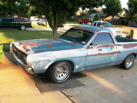 1973 Ford Ranchero - Late-1960s Ford Ranchero coupe utility sitting in a suburban driveway, photographed from a high front three-quarter driver's-side angle. Th…