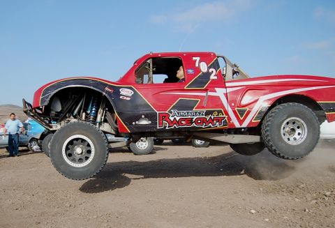 1992 Ford Explorer - A custom off-road truck with racing decals is airborne during an event.