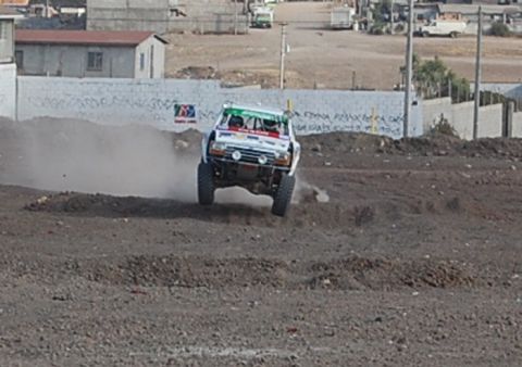 1992 Ford Explorer - This off-road race truck is captured mid-air during a race event, viewed from the front.