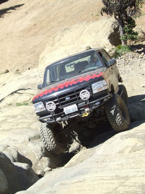 1979 Ford Bronco - This modified Ford Bronco is tackling a challenging off-road course with its suspension and tires clearly visible.
