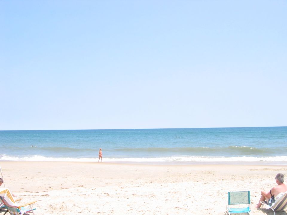 People relaxing on a sandy beach with the ocean in the background