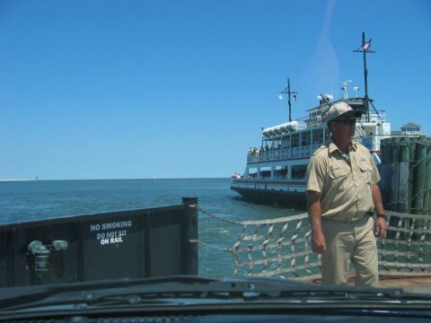 1985 Ford LTD Crown Victoria - A ferry operates on a clear day with a crew member standing on deck.