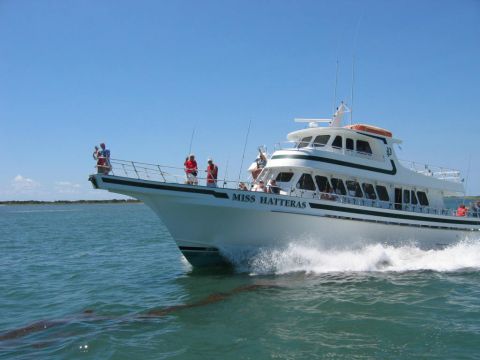 1985 Ford LTD Crown Victoria - The Miss Hatteras fishing boat cruises through the water under a clear blue sky.