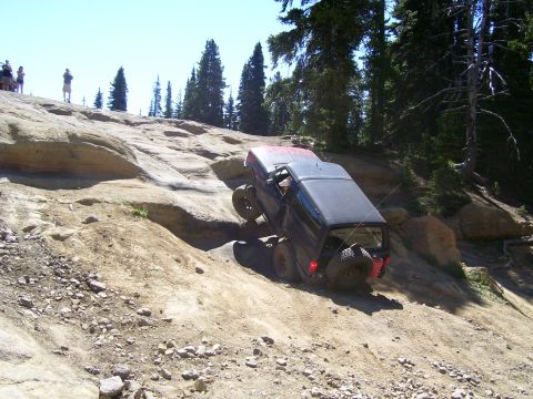 1989 Ford Bronco - A modified SUV tackles a challenging off-road course on a sunny day.