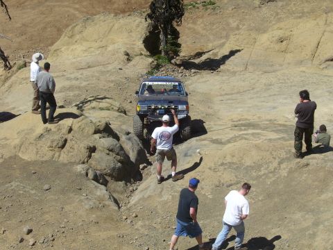 1989 Ford Bronco - A 1989 Ford Bronco navigates a challenging rocky trail with several onlookers.