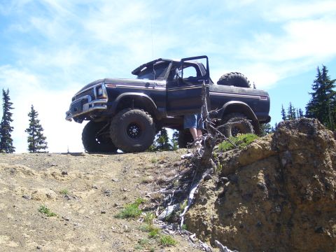 1989 Ford Bronco - This lifted Ford Bronco is parked on a rocky ridge, ready for off-road adventure.