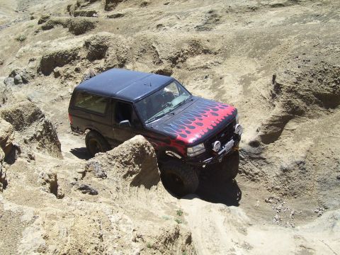 1989 Ford Bronco - This 1989 Ford Bronco is shown tackling a challenging off-road trail with steep inclines and rocky terrain.