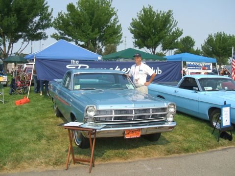 1974 Ford Ranchero - A man poses with his classic Ford Ranchero at an outdoor car show, with other vehicles and tents in the background.