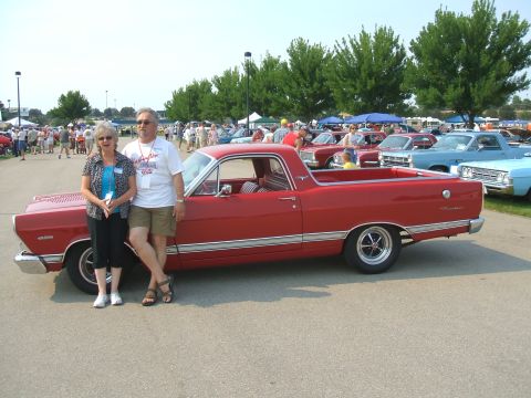 1974 Ford Ranchero - A red 1968 Ford Ranchero is displayed at a car show with attendees in the background.