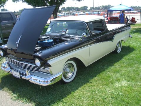 1974 Ford Ranchero - A two-tone black and white 1957 Ford Ranchero is displayed with its hood open at a car show.