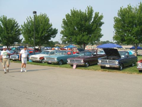 1974 Ford Ranchero - Several classic Ford Rancheros are displayed at a car show, with one dark blue model showing its engine.