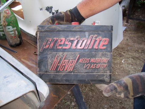 1955 Ford Customline - A vintage Presto-Lite battery is held by gloved hands, with text indicating it requires water.