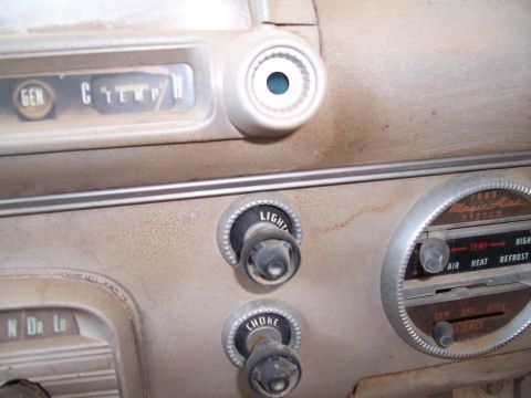 1955 Ford Customline - Close-up of a vintage car's interior dashboard, showing various controls and gauges.