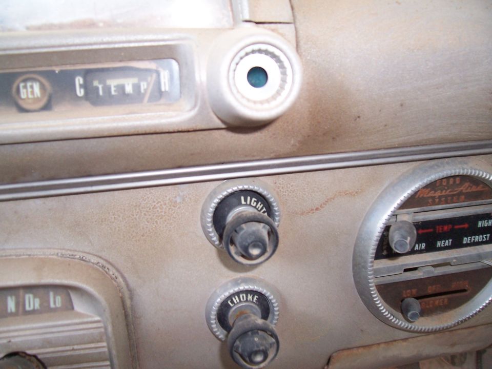 Dusty car dashboard with temperature and fan controls, and a GEN and C TEMP/MPH gauge