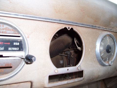 1955 Ford Customline - The interior of a 1955 Ford Customline shows a dusty dashboard with visible gauges and controls.