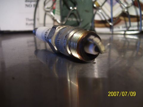 1990 Jeep Cherokee - A close-up view of a single spark plug, showing some wear and tear.