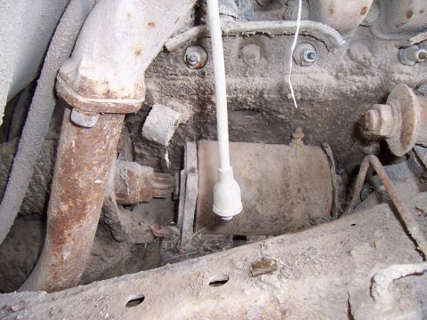 1955 Ford Customline - Close-up view of a dirty and rusty engine starter motor and exhaust pipe.