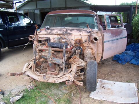 1955 Ford Customline - This vintage Ford pickup is in a state of disassembly, with its engine compartment open and parts removed.