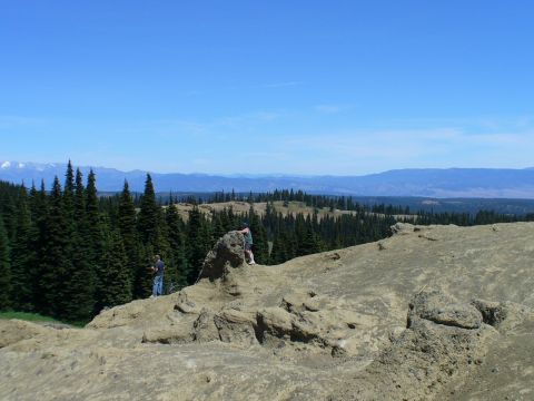 1978 Ford Bronco - A scenic overlook with people exploring the rocky terrain and enjoying the expansive view of the valley and mountains.